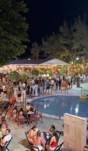 a group of people sitting around a pool at night at Flat Carneiros - Hotel Marinas in Tamandaré +11 photos