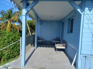 a blue house with a porch with two chairs at Maya Dream in Morne Blanc