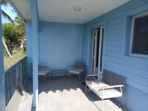 a blue house with chairs on a porch at Maya Dream in Morne Blanc