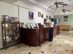 a woman standing at a counter with a child at โรงแรมลักเซอรี่ Luxury Hotel in Kanchanaburi City