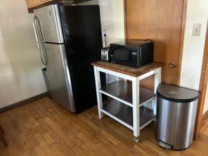 a microwave on a table next to a refrigerator at 4 Room Sleeps 8plus Tranquil Home in Santa Cruz