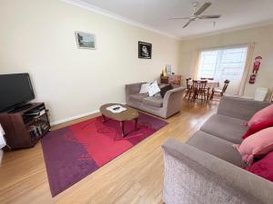 a living room with a couch and a table at Chalkers Unit - Bring your own linen in South West Rocks