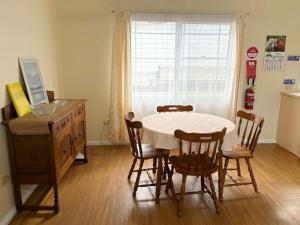 a dining room with a table and chairs and a window at Chalkers Unit - Bring your own linen in South West Rocks