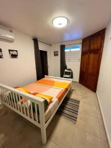 a bedroom with a bed and a chair in it at Charming house in a natural setting in Sainte-Rose
