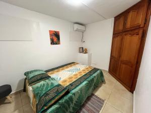 a small bedroom with a bed and a wooden door at Charming house in a natural setting in Sainte-Rose