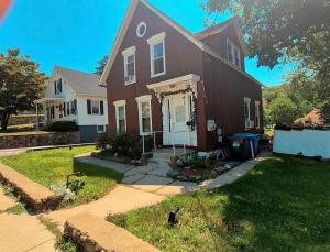 a brown house with a white door and a yard at Humble beginning 605 EM in Norwich