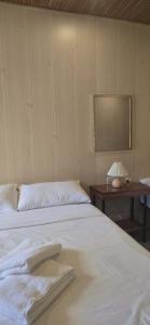 a bedroom with a white bed and a table with a lamp at Kasyatel in Impasugong