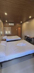 two beds in a room with two tables at Kasyatel in Impasugong