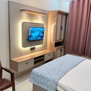 a room with a bed and a tv on a wall at Hotel Friends Residency in Bijaipur