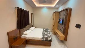 a small bedroom with a bed and a wooden cabinet at Hotel Friends Residency in Bijaipur +7 photos