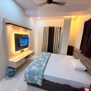 a bedroom with a bed with a tv on the wall at Hotel Friends Residency in Bijaipur
