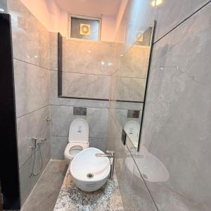 a bathroom with two toilets and a sink and a mirror at Hotel Friends Residency in Bijaipur