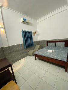 a room with a bed and a chair in it at Nhà Nghỉ 36 in Ga Trảng Bôm