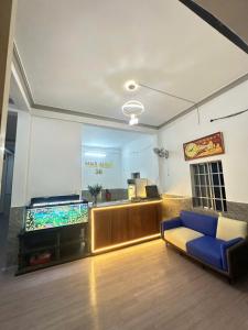 a living room with a blue couch and a desk at Nhà Nghỉ 36 in Ga Trảng Bôm