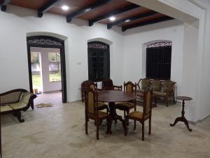 a dining room with a wooden table and chairs at Villa77 Benthota in Bentota