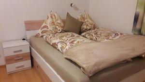 Bett mit Kissen und Nachttisch in der Unterkunft Chalet Sunnseitn in Radstadt