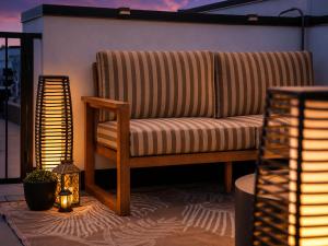 a couch sitting on a balcony with a lamp at Roami at Zuni in Denver