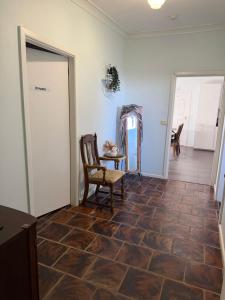 a hallway with a chair and a table and a door at Opal St Homestay in Lightning Ridge