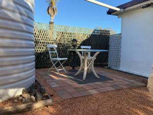 a table and two chairs on a patio at Opal St Homestay in Lightning Ridge +2 photos