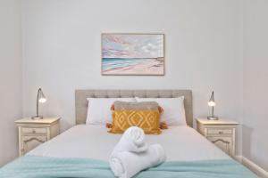a bedroom with a bed with towels on it at Serenity Place in Mannering Park