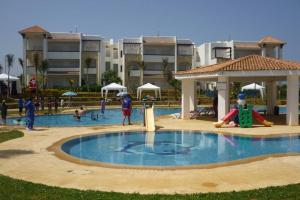 un grupo de personas jugando en una piscina en un complejo en Assilah Marina golf en Asilah