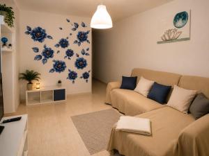 a living room with a couch and blue flowers on the wall at MiVida in San Bartolomé