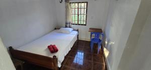 a small bedroom with a bed and a blue chair at Khmer House Guesthouse in Kep