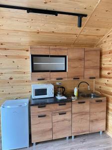 a kitchen with a microwave and a sink at Барнхаус in Cholpon-Ata