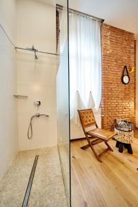 baño con ducha de cristal y silla en Indigo Centar, en Zagreb 72 fotos más