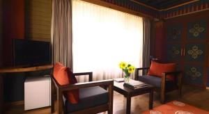 a living room with a couch and a table and a window at Hotel Valley Thimphu in Tshalunang