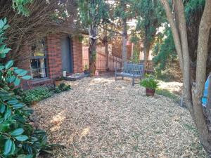 a bench sitting in a yard next to a house at Private Studio Ensuite & Kitchenette in Glen Waverley