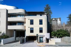 a large white building with a blue sky at The Park OASIS Burwood in Sydney