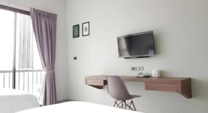 a bedroom with a desk with a tv and a chair at @Sleep in Ban Rang Faet