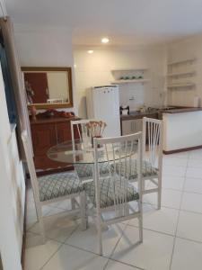 a kitchen with a table and chairs and a refrigerator at Residencial Ribeiro in Salvador