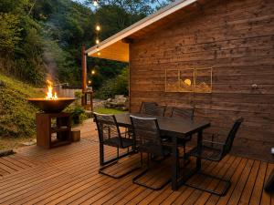 eine Holzterrasse mit Tisch und Stühlen sowie einer Feuerstelle in der Unterkunft RENEST in Kōbe