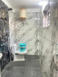 a bathroom with a toilet and a sink at Nilgiris Stayz - Home Stay at Ooty in Ooty