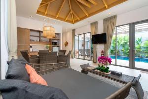 a living room with a couch and a table at Tropical Private Pool Villa Dalaa 9 in Kamala Beach