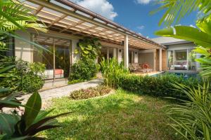 an exterior view of a house with a pergola at Tropical Private Pool Villa Dalaa 9 in Kamala Beach