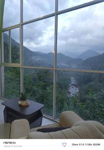 a living room with a large window with a view at Adventure Manor in Kitulgala
