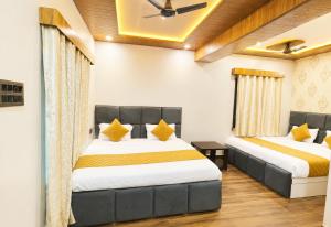 a bedroom with two beds in a room at Hotel Priyanscy Palace in Sonepur