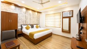 a hotel room with a bed and a television at Hotel Priyanscy Palace in Sonepur