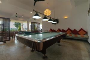 a pool table in the middle of a room at Jim's Farm Villas in Madawala