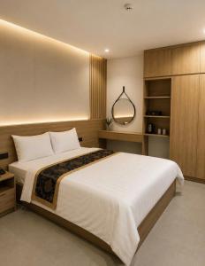 a bedroom with a large bed and a mirror at An Bình Luxury Hotel in Bắc Giang +6 photos