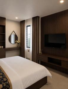 a bedroom with a bed and a flat screen tv at An Bình Luxury Hotel in Bắc Giang