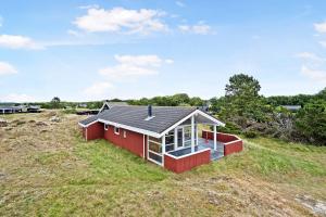 a small red house on a grassy hill at Holiday House On Fanø Near The Sea in Fanø