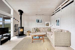 a living room with a couch and a fireplace at Holiday House On Fanø Near The Sea in Fanø