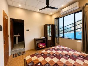 a bedroom with a bed and a large window at Kamlkash niwas homestay in Rishīkesh