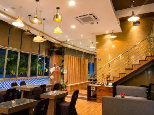 a restaurant with tables and chairs and stairs at Vio Hotel Pasteur in Bandung