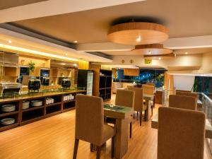 a restaurant with a table and chairs and a kitchen at Vio Hotel Pasteur in Bandung