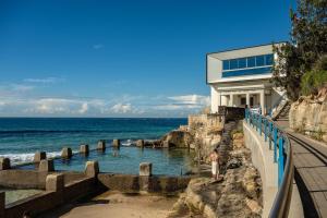 a man standing in the water in front of a building at Coogee Bay Boutique Hotel in Sydney